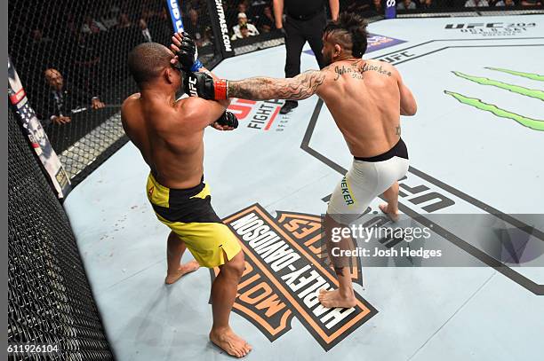 John Lineker of Brazil punches John Dodson in their bantamweight bout during the UFC Fight Night event at the Moda Center on October 1, 2016 in...