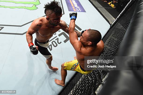 John Lineker of Brazil punches John Dodson in their bantamweight bout during the UFC Fight Night event at the Moda Center on October 1, 2016 in...