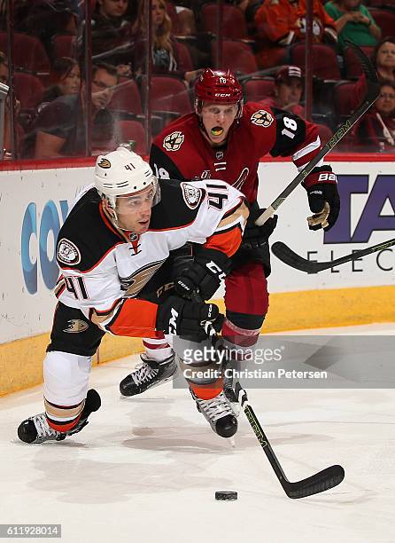 Corey Tropp of the Anaheim Ducks skates with the puck ahead of Christian Dvorak of the Arizona Coyotes during the preseason NHL game at Gila River...