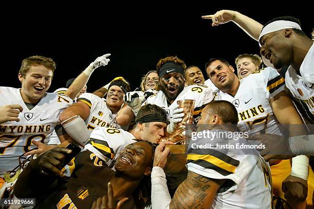 The Wyoming Cowboys celebrate with The Bronze Boot after winning the border war against Colorado State Rams 38-17 at Sonny Lubick Field at Hughes...