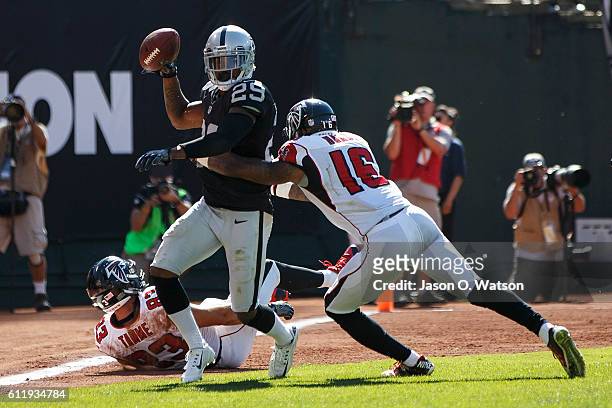 Cornerback David Amerson of the Oakland Raiders intercepts a pass intended for tight end Jacob Tamme of the Atlanta Falcons during the third quarter...
