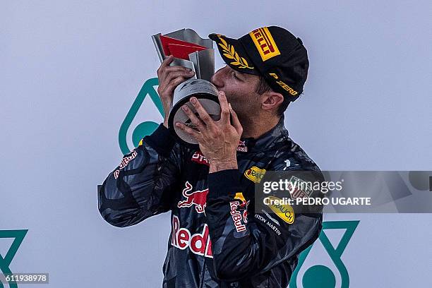 Red Bull Racing's Australian driver Daniel Ricciardo kisses his trophy on the podium after winning the Formula One Malaysian Grand Prix in Sepang on...