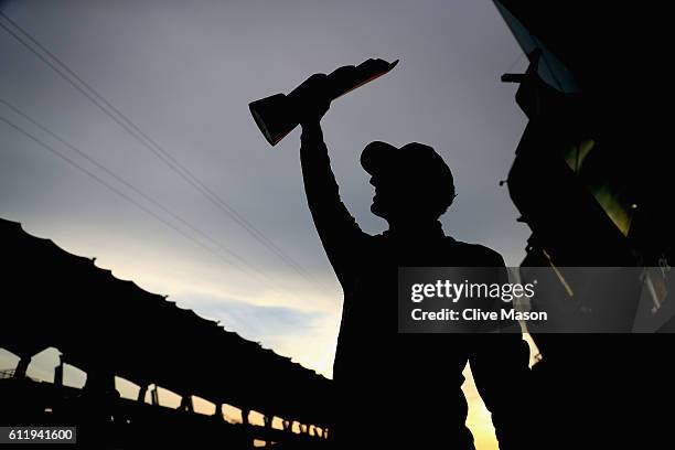 Daniel Ricciardo of Australia and Red Bull Racing shows his trophy off to the fans during the Malaysia Formula One Grand Prix at Sepang Circuit on...