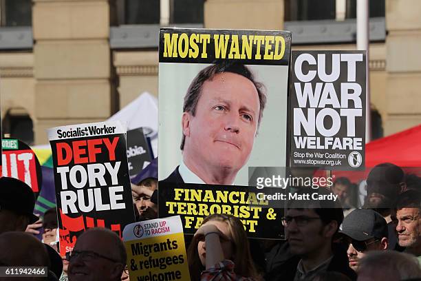 Protesters hold a sign calling former British Prime Minister David Cameron a "financial terrorist and facist" during a TUC demonstration against...