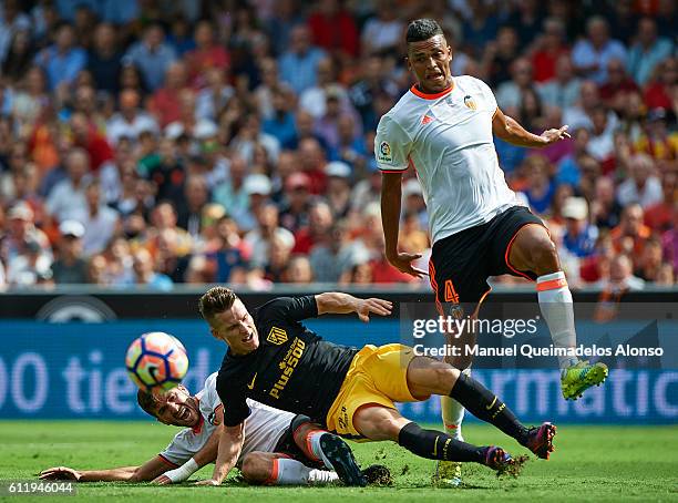 Kevin Gameiro of Atletico de Madrid is tackled by Jose Luis Gaya and Aderlan Santos of Valencia during the La Liga match between Valencia CF and...