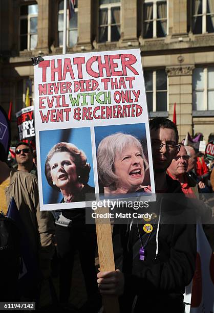 Protester holds a sign comparing former British Prime Minister Margaret Thatcher to current British Prime Minister Theresa May during a demonstration...