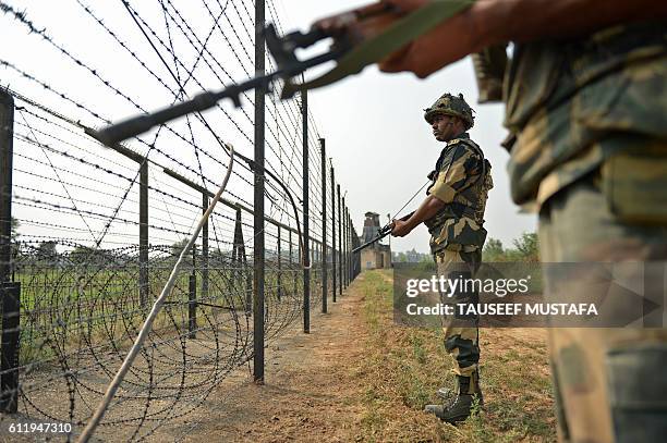Indian Border Security Force soldiers take up positions at an outpost along a fence at the India-Pakistan border in R.S Pora south-west of Jammu on...