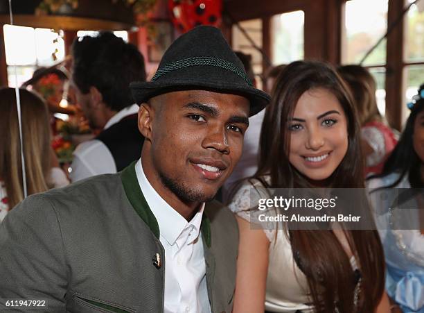 Douglas Costa of FC Bayern Muenchen and his wife Louisa Ramos attend the Oktoberfest beer festival at Kaefer Wiesenschaenke tent at Theresienwiese on...