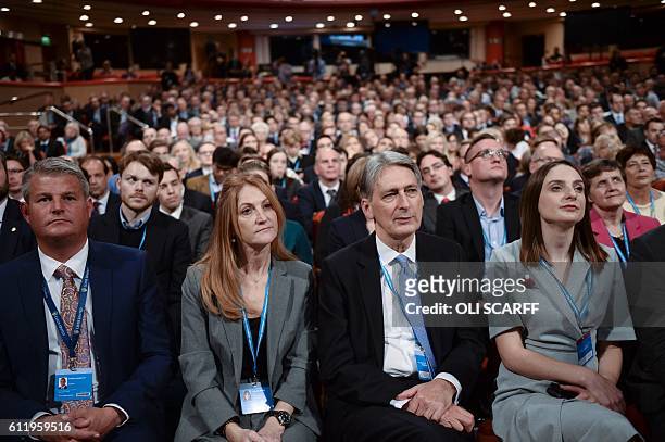 British Chancellor of the Exchequer Philip Hammond sits in the audience with his wife Susan Williams-Walker listening to the speech of British Prime...