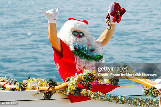 santa claus in canoe flashing shaka - hawaii christmas stockfoto's en -beelden