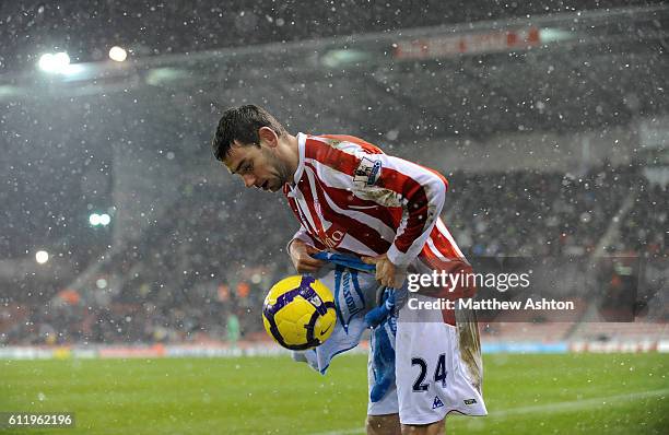 Rory Delap of Stoke City uses a towel to dry the ball in the snow