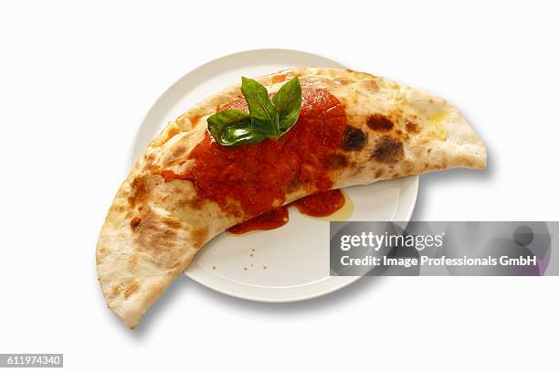 calzone with tomato sauce and basil - calzone stock-fotos und bilder