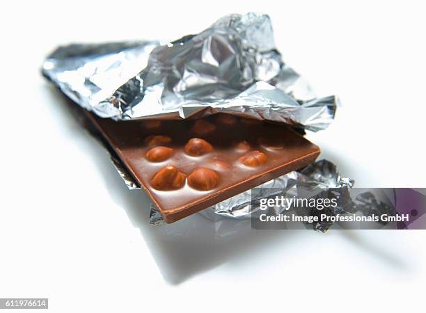 an opened bar of nut chocolate - open chocolate bar stock pictures, royalty-free photos & images