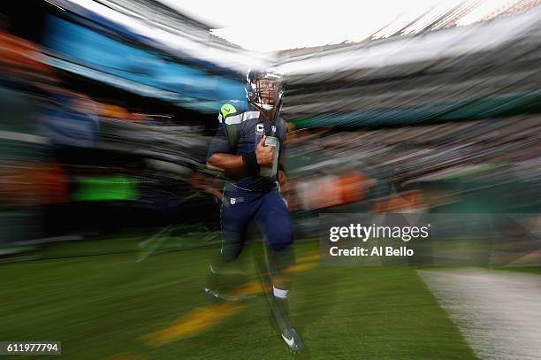 Quarterback Russell Wilson of the Seattle Seahawks runs onto the field before the game against the New York Jets at MetLife Stadium on October 2,...
