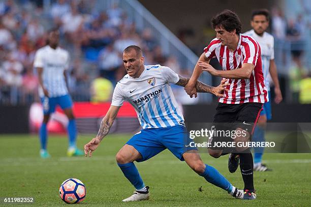 Malaga's forward Sandro Ramirez vies with Athletic Bilbaos defender Mikel San Jose during the Spanish league football match Malaga CF vs Athletic...