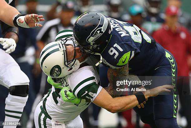 Cassius Marsh of the Seattle Seahawks hits his helmet against quarterback Ryan Fitzpatrick of the New York Jets for a penalty 'Roughing the Passer'...