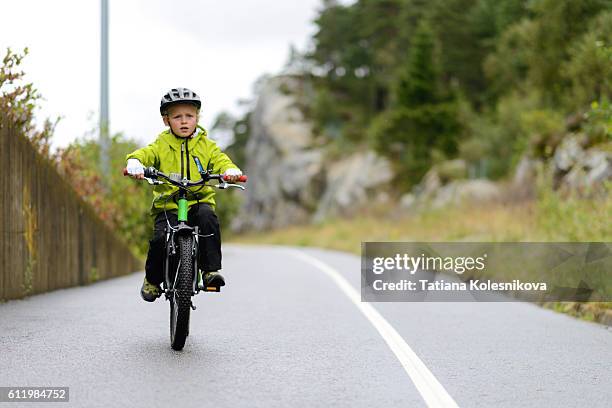 child cycling on cycling lane in a small european city. - boy in hard hat stock pictures, royalty-free photos & images