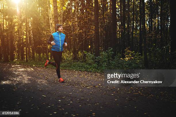 homme courant dans la forêt au lever du soleil - jogging photos et images de collection