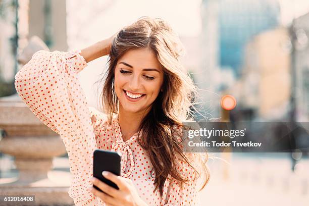 texting on the phone - beautiful women stockfoto's en -beelden