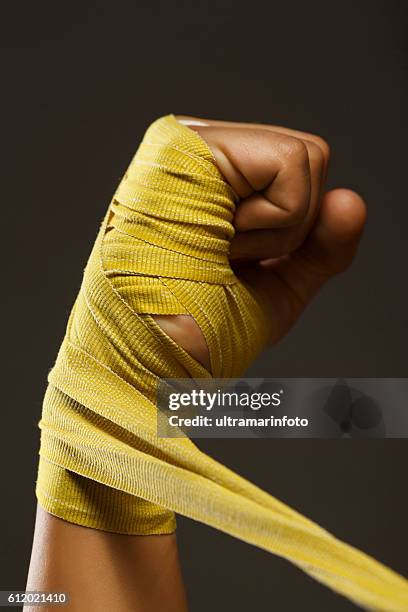 puño femenino kickboxing mujer atlética envolviendo las manos con envolturas de boxeo - boxing media workouts fotografías e imágenes de stock