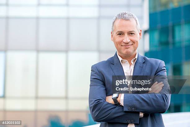 happy satisfied mature businessman looking at camera - portrait man suit smiling light background stock pictures, royalty-free photos & images