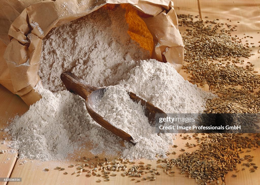 Rye flour in paper sack, scoop and grains