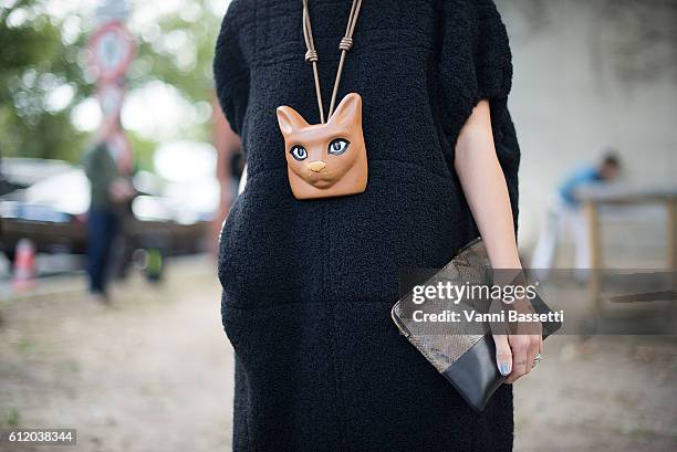 Guest poses wearing Celine and Loewe necklace after the Celine show at the Tennis Club de Paris during Paris Fashion Week Womenswear SS17 on October...