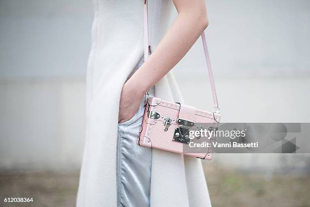 Guest poses with a Louis Vuitton bag after the Celine show at the Tennis Club de Paris during Paris Fashion Week Womenswear SS17 on October 2, 2016...