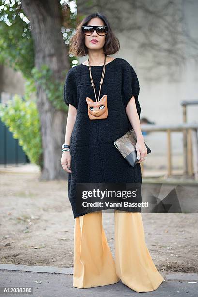 Guest poses wearing Celine and Loewe necklace after the Celine show at the Tennis Club de Paris during Paris Fashion Week Womenswear SS17 on October...