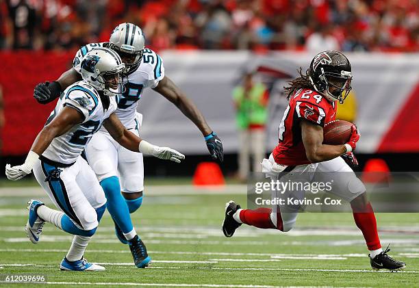 Devonta Freeman of the Atlanta Falcons rushes away from Bene Benwikere and Thomas Davis of the Carolina Panthers at Georgia Dome on October 2, 2016...