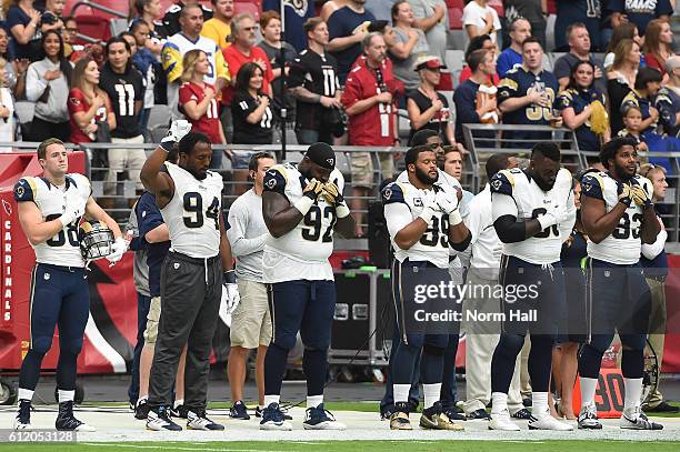 Defensive end Robert Quinn of the Los Angeles Rams holds up his fist during the national anthem prior to the NFL game against the Arizona Cardinals...