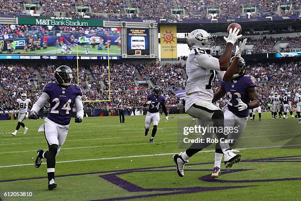 Michael Crabtree of the Oakland Raiders catches a fourth quarter touchdown pass in front of Kendrick Lewis and Kyle Arrington of the Baltimore Ravens...