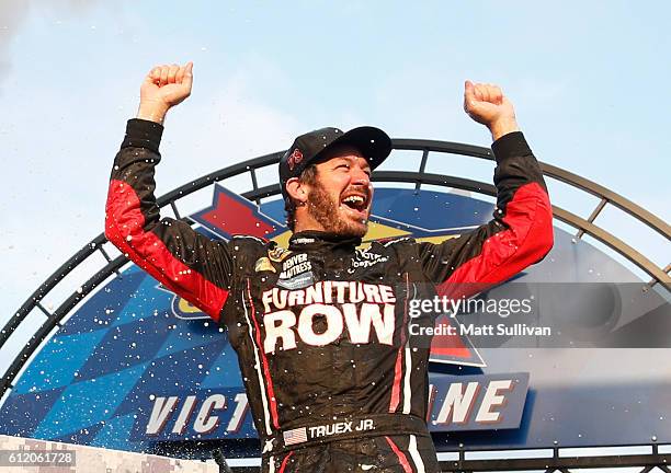 Martin Truex Jr., driver of the Furniture Row/Denver Mattress Toyota, celebrates in Victory Lane after winning the NASCAR Sprint Cup Series Citizen...