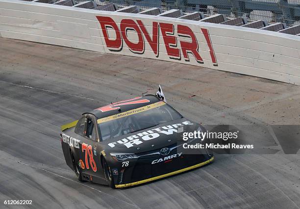 Martin Truex Jr., driver of the Furniture Row/Denver Mattress Toyota, celebrates with the checkered flag after winning the NASCAR Sprint Cup Series...