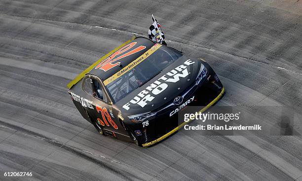 Martin Truex Jr., driver of the Furniture Row/Denver Mattress Toyota, celebrates with the checkered flag after winning the NASCAR Sprint Cup Series...