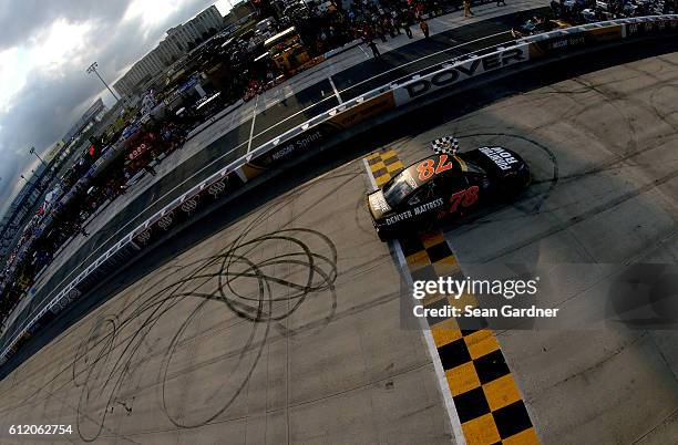 Martin Truex Jr., driver of the Furniture Row/Denver Mattress Toyota, celebrates with the checkered flag after winning the NASCAR Sprint Cup Series...