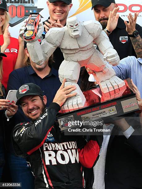 Martin Truex Jr., driver of the Furniture Row/Denver Mattress Toyota, celebrates with the trophy in Victory Lane after winning the NASCAR Sprint Cup...