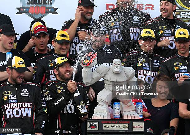 Martin Truex Jr., driver of the Furniture Row/Denver Mattress Toyota, celebrates with the trophy in Victory Lane after winning the NASCAR Sprint Cup...