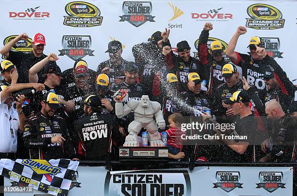 Martin Truex Jr., driver of the Furniture Row/Denver Mattress Toyota, celebrates with the trophy in Victory Lane after winning the NASCAR Sprint Cup...