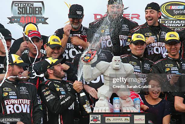 Martin Truex Jr., driver of the Furniture Row/Denver Mattress Toyota, celebrates with the trophy in Victory Lane after winning the NASCAR Sprint Cup...