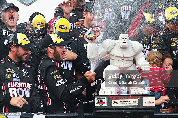 Martin Truex Jr., driver of the Furniture Row/Denver Mattress Toyota, celebrates with the trophy in Victory Lane after winning the NASCAR Sprint Cup...