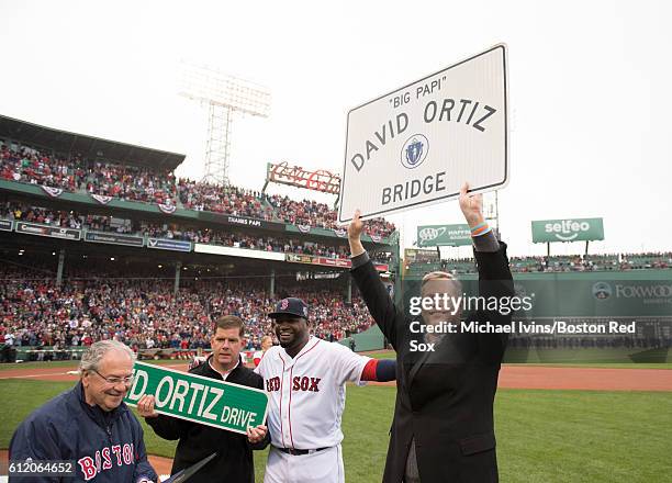 Massachusetts governor Charlie Baker holds up a sign to be put up on the Brookline Avenue bridge in honor of David Ortiz of the Boston Red Sox during...