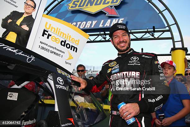Martin Truex Jr., driver of the Furniture Row/Denver Mattress Toyota, poses with the winners decal in Victory Lane after winning the NASCAR Sprint...