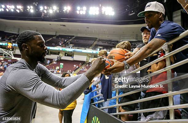 Lance Stephenson of the New Orleans Pelicans signs autographs for fans before the game against the Dallas Mavericks during a preseason game on...