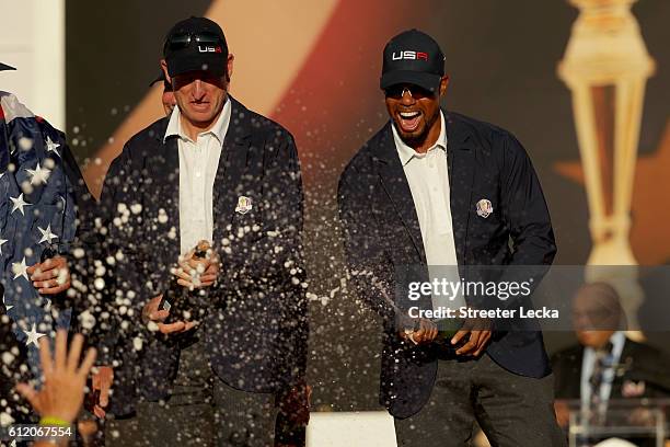 Vice-captains Jim Furyk and vice-captain Tiger Woods of the United States spray champagne after winning the Ryder Cup during the closing ceremony of...
