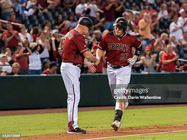 Brandon Drury of the Arizona Diamondbacks homers to right field and is congratulated by third base coach Matt Williams in the eighth inning of the...
