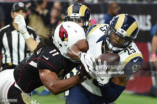 Strong safety T.J. McDonald of the Los Angeles Rams intercepts a pass in front of wide receiver Larry Fitzgerald of the Arizona Cardinals during the...