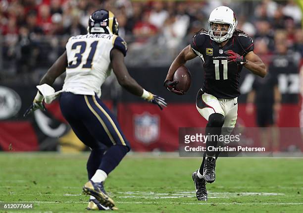Wide receiver Larry Fitzgerald of the Arizona Cardinals runs with the ball in front of free safety Maurice Alexander of the Los Angeles Rams during...