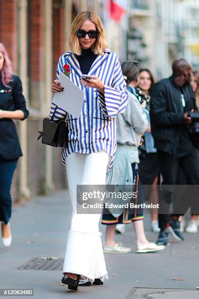 Candela Novembre is wearing a striped shirt, and white pants, outside the Galliano show, during Paris Fashion Week Spring Summer 2017, on October 2,...