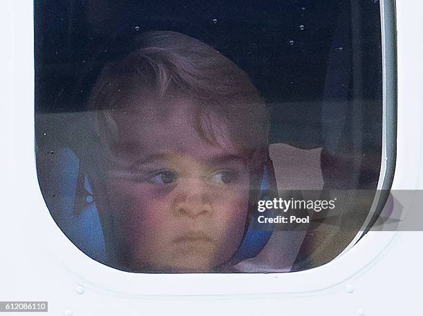 Prince George of Cambridge presses his face against the window as he leaves from Victoria Harbour aboard a sea-plane on the final day of their Royal...